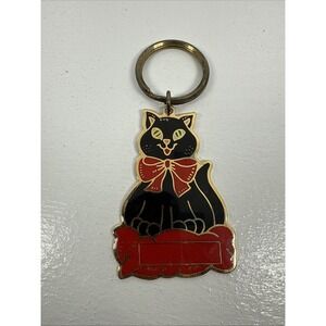Black cat enamel keychain with gold-toned metal accents and a red bow